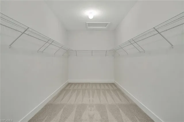 a bedroom with a bed and a lamp on the dresser