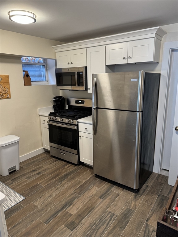 2 Sackville Street, Unit 1 Boston, MA 02129 - Photo 3 of 8 a kitchen with a refrigerator stove and wooden floor