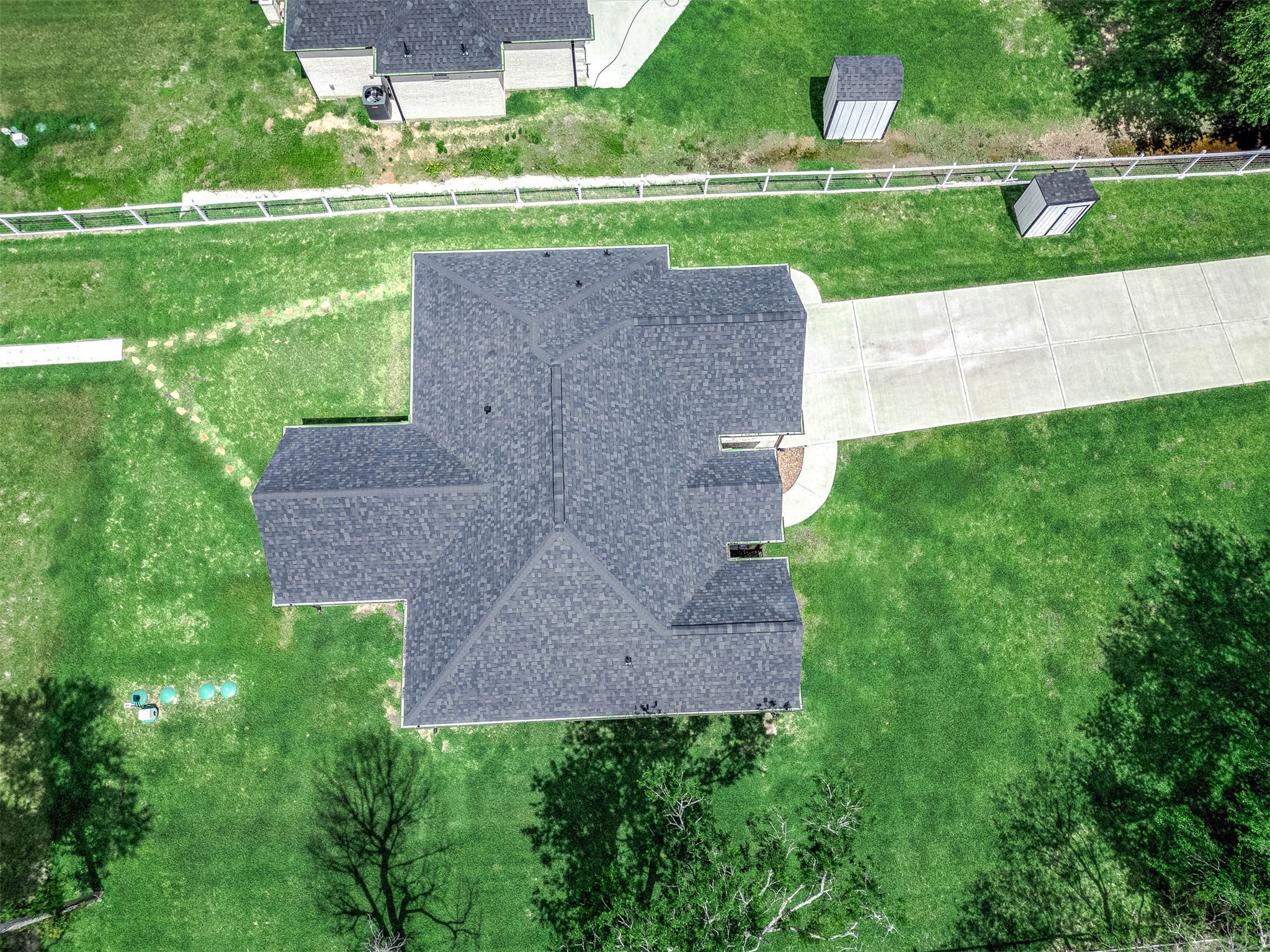 8032 Short Road Needville, TX 77461 - Photo 45 of 50 This aerial view highlights the home’s impressive curb appeal, extended driveway, fenced areas, and well-maintained outdoor space. The layout offers plenty of usable land along with additional structures that add functionality and flexibility to the property.