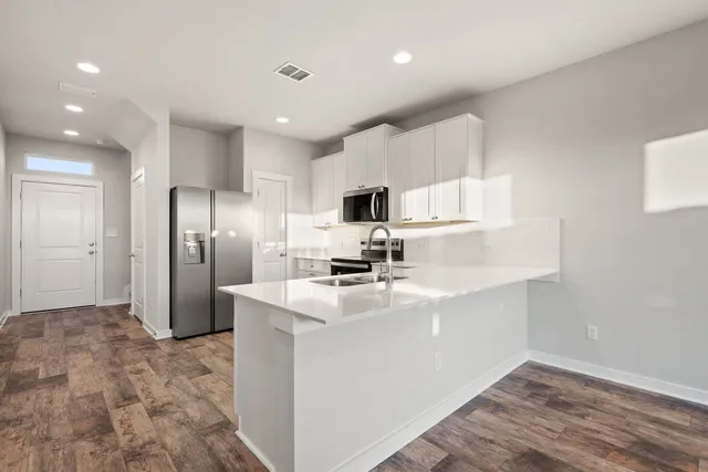 a kitchen with white cabinets and stainless steel appliances