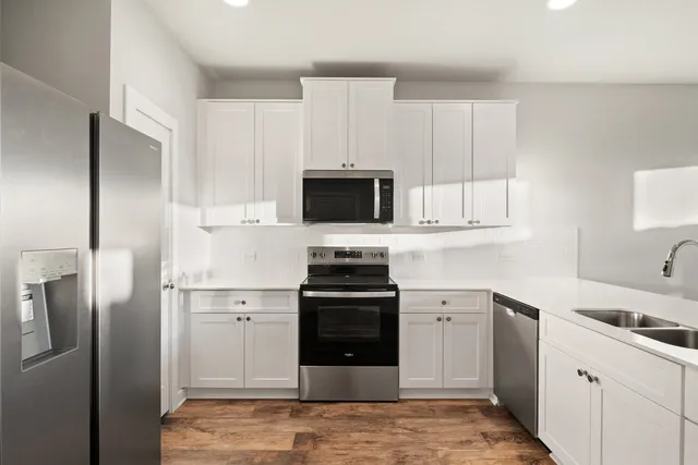 a kitchen with a sink cabinets and wooden floor