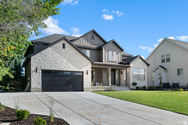 2724 Mt Jordan Road Sandy, UT 84092 - Photo 4 of 39 Contemporary exterior featuring a combination of light-toned stone veneer and dark vertical siding