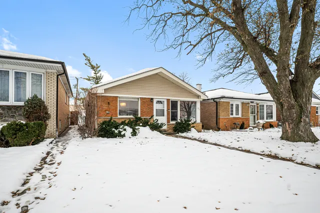 a front view of a house with a yard covered with snow in front of house