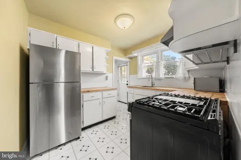 a kitchen with stainless steel appliances granite countertop a refrigerator and a stove