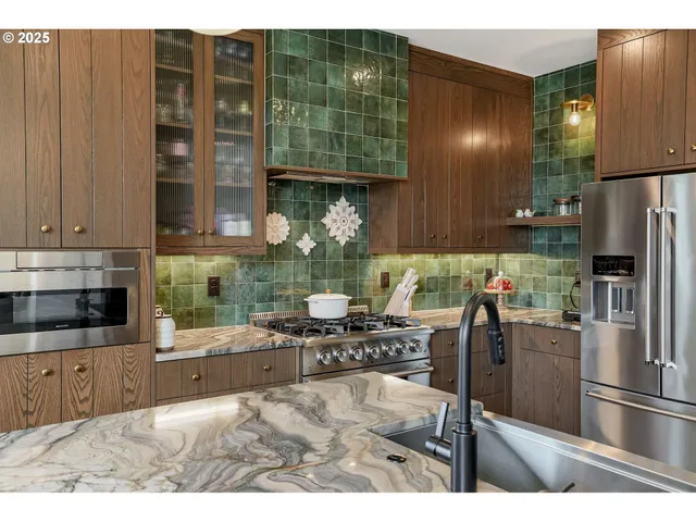 a kitchen with stainless steel appliances kitchen island granite countertop a refrigerator and a stove top oven