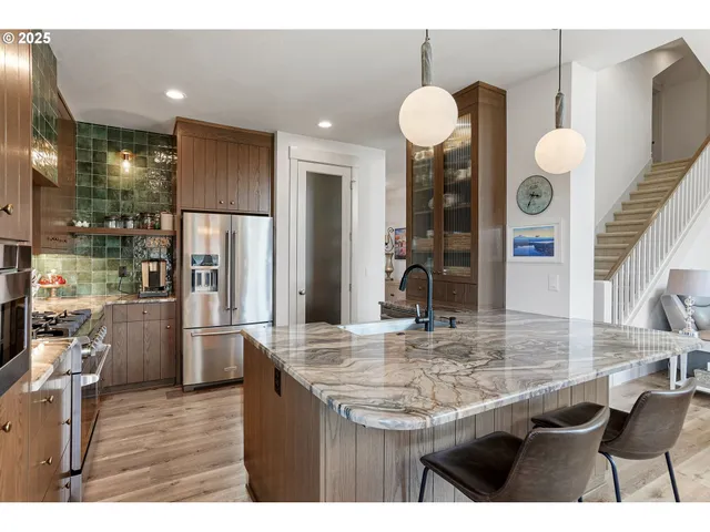 a kitchen with stainless steel appliances kitchen island granite countertop a table and chairs in it