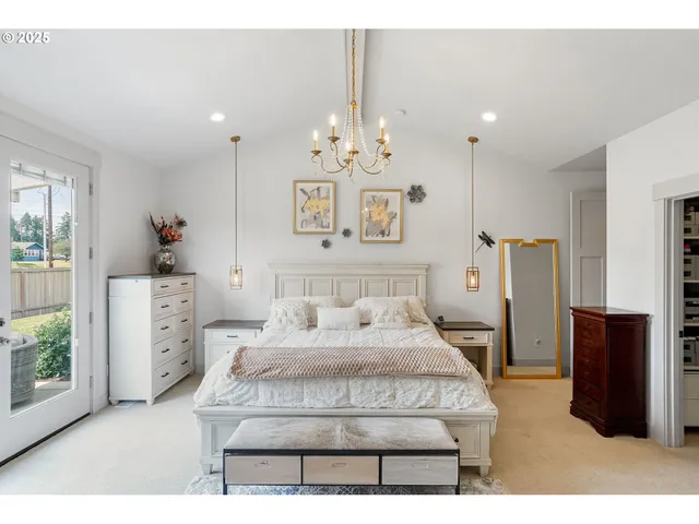 a bedroom with a large bed and a chandelier