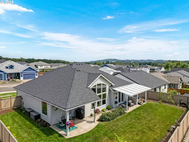 an aerial view of residential houses with yard and mountain view in back