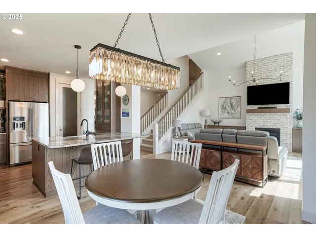 a dining room with wooden floor a chandelier a wooden table and chairs
