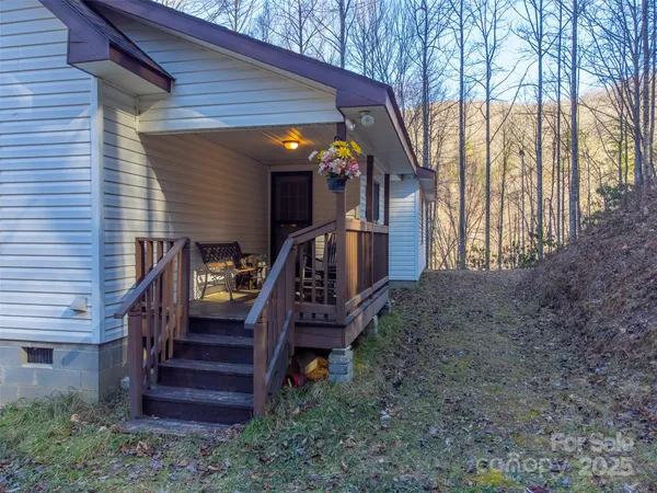 a view of a house with a small yard and wooden deck