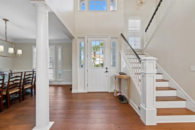 a living room with furniture a chandelier and a dining table