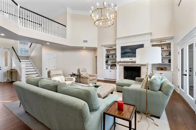 a view of a dining room and livingroom with furniture wooden floor a chandelier