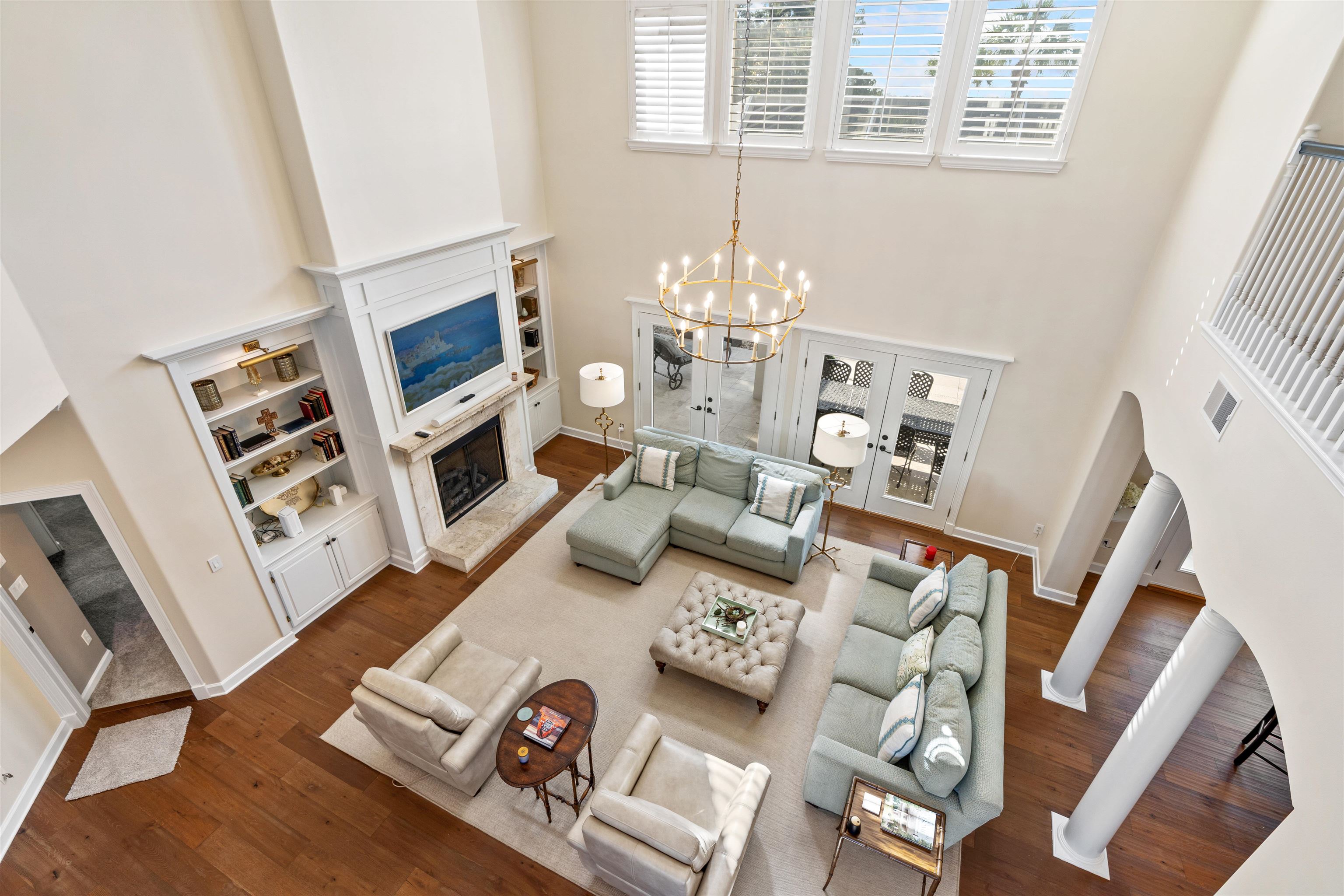 207 Marshside Drive St. Augustine, FL 32080 - Photo 17 of 87 Living room with a fireplace with raised hearth, a towering ceiling, dark wood finished floors, arched walkways, and french doors