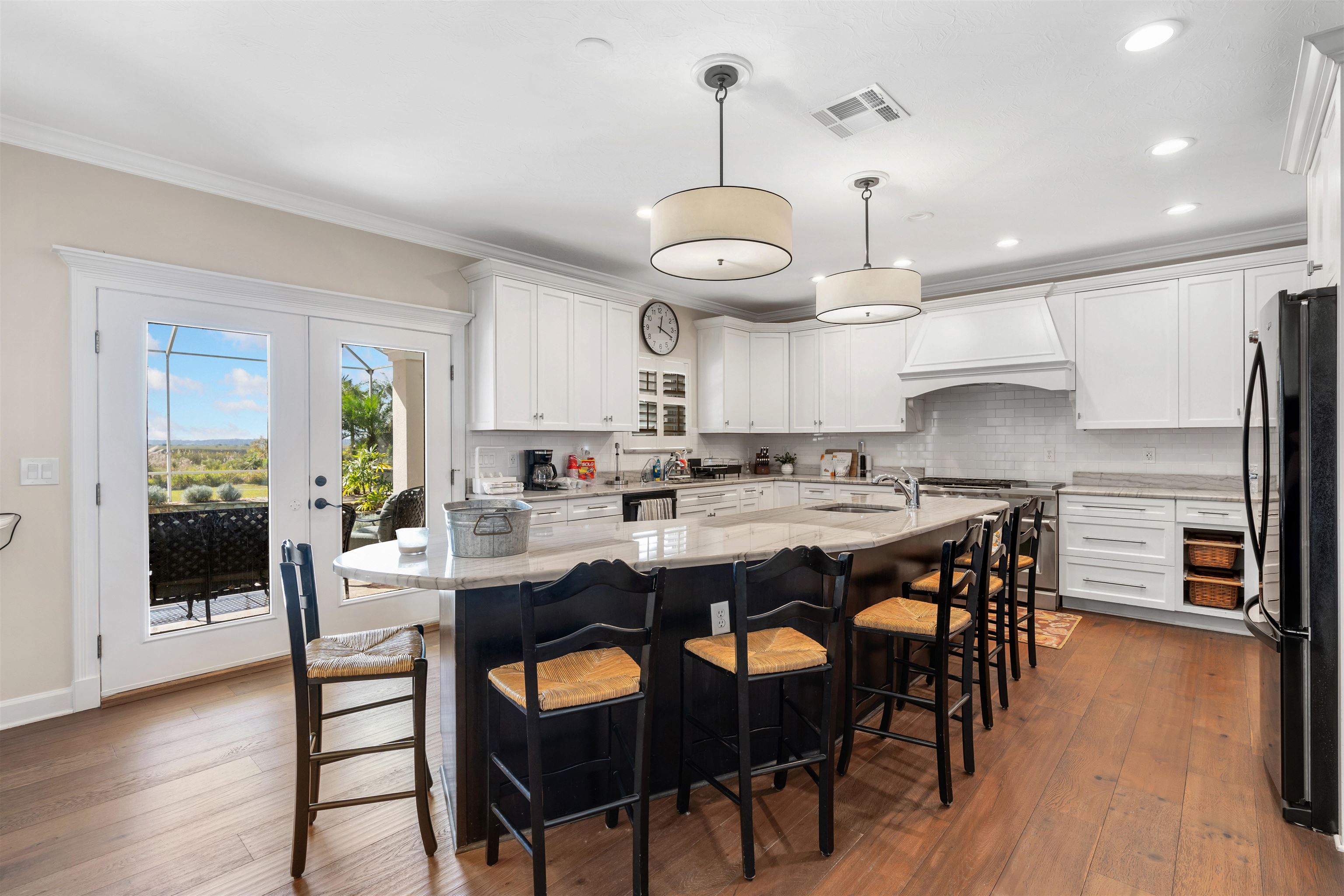 207 Marshside Drive St. Augustine, FL 32080 - Photo 18 of 87 Kitchen featuring ornamental molding, a kitchen breakfast bar, white cabinetry, a kitchen island with sink, and recessed lighting