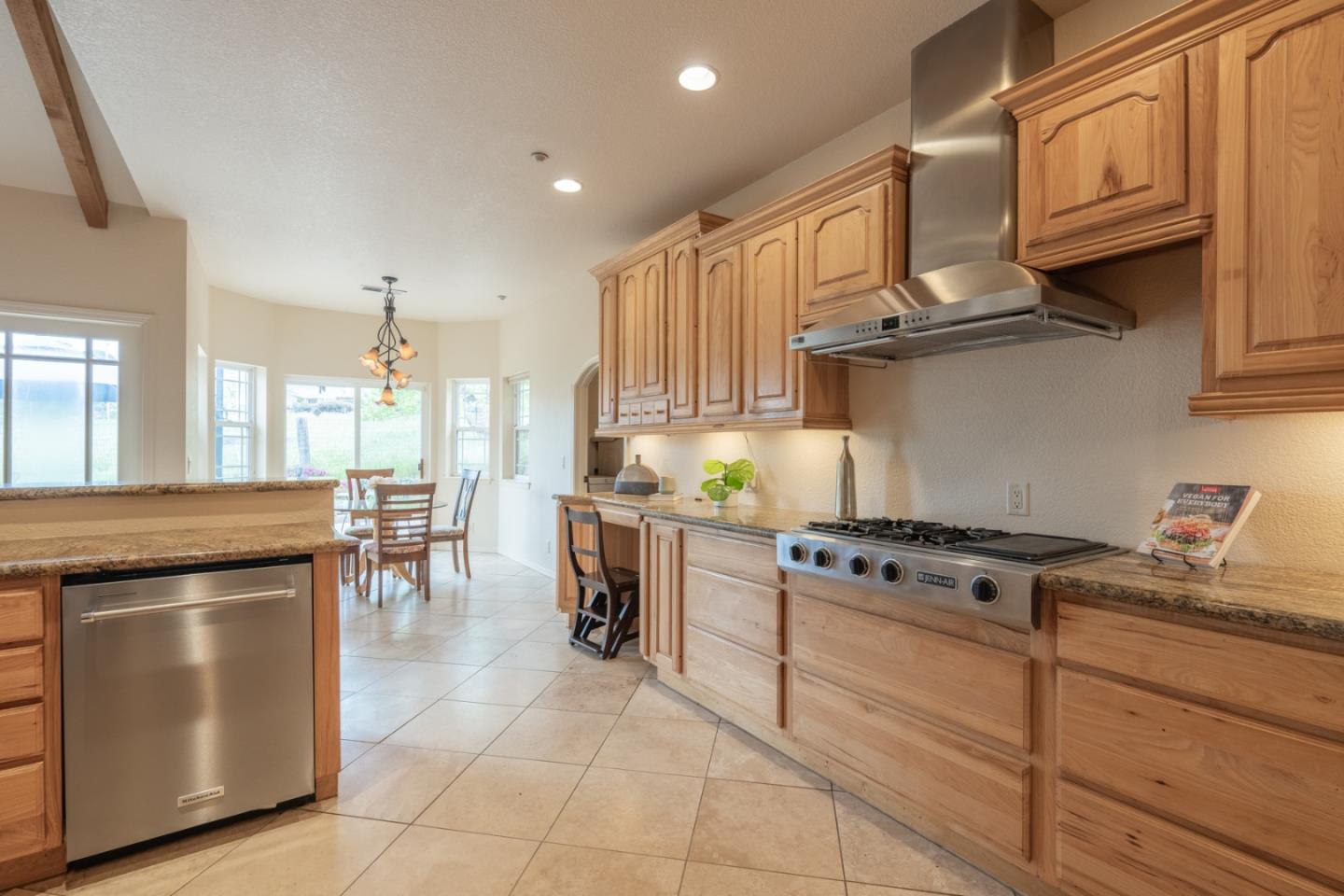 10233 Reese Circle Salinas, CA 93907 - Photo 12 of 49 a kitchen with kitchen island granite countertop wooden cabinets and a stove