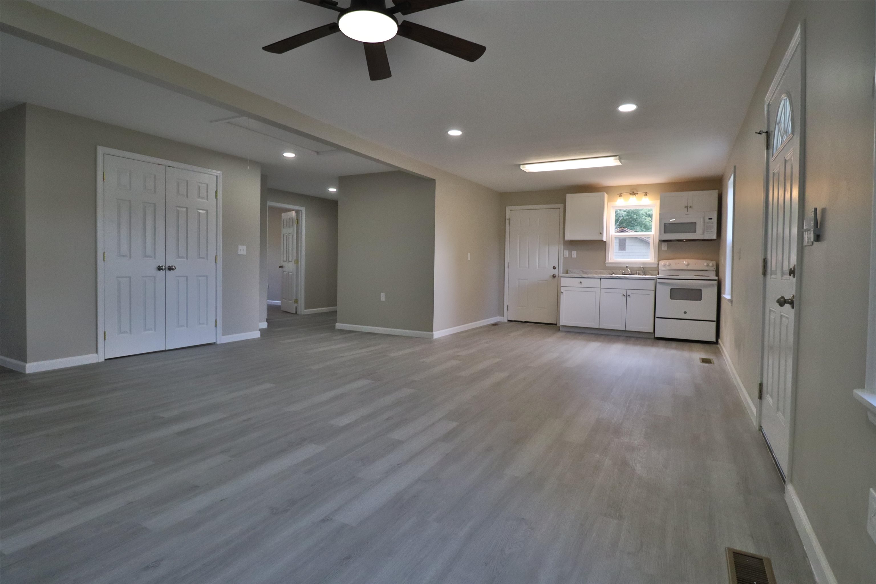224 Kellar Avenue Ripley, TN 38063 - Photo 8 of 30 a view of an empty room and kitchen with wooden floor