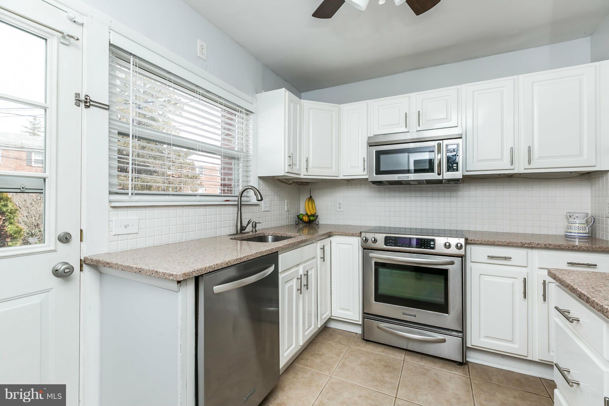 1947 Edgewood Road Baltimore, MD 21286 - Photo 12 of 28 a kitchen with stainless steel appliances granite countertop a sink dishwasher a stove and a microwave oven with cabinets