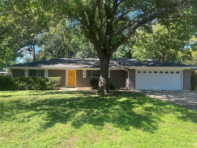 a white house that has a tree in front of it