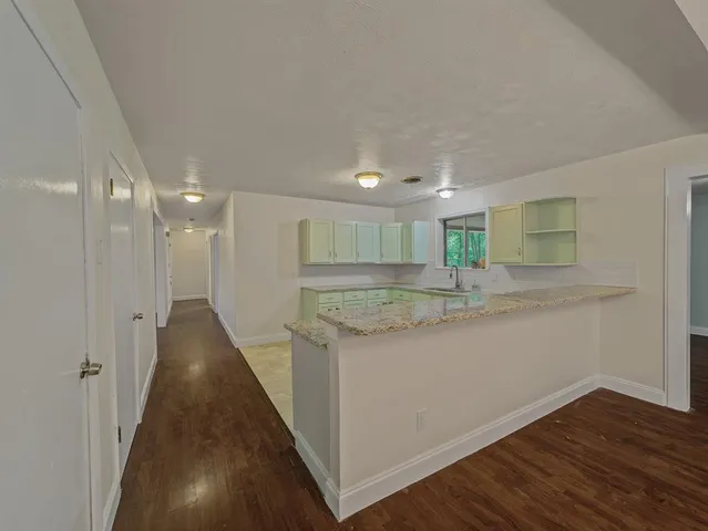 a view of a kitchen with wooden floor and a sink