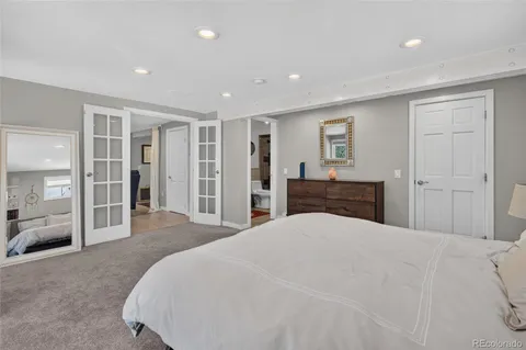 a large bedroom with a bed and a large mirror