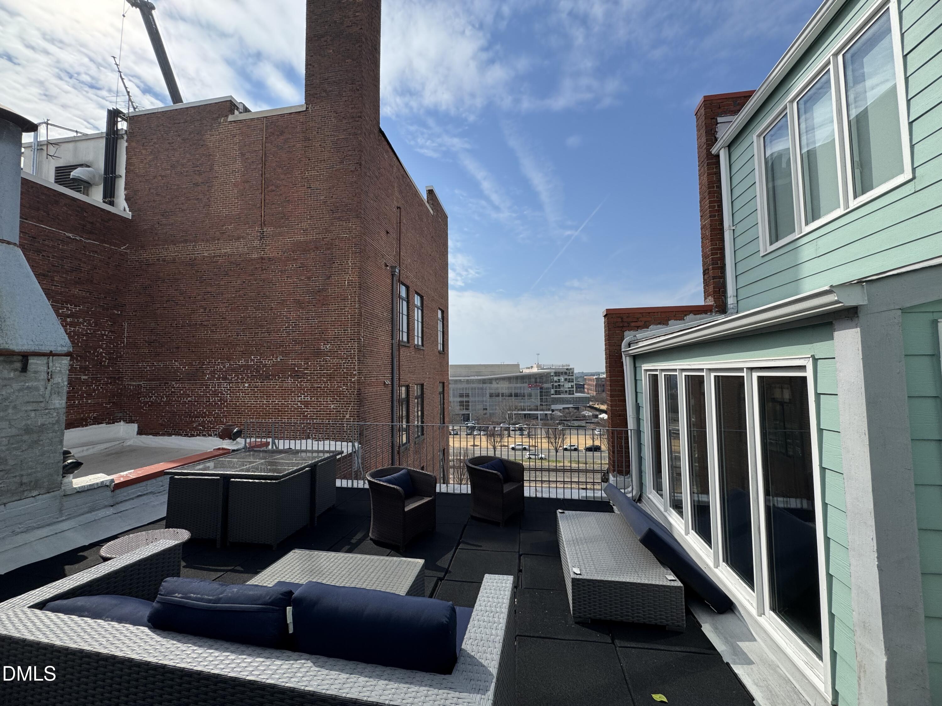 109 West Main Street, Unit 402 Durham, NC 27701 - Photo 6 of 19 a view of a balcony with chairs and a barbeque