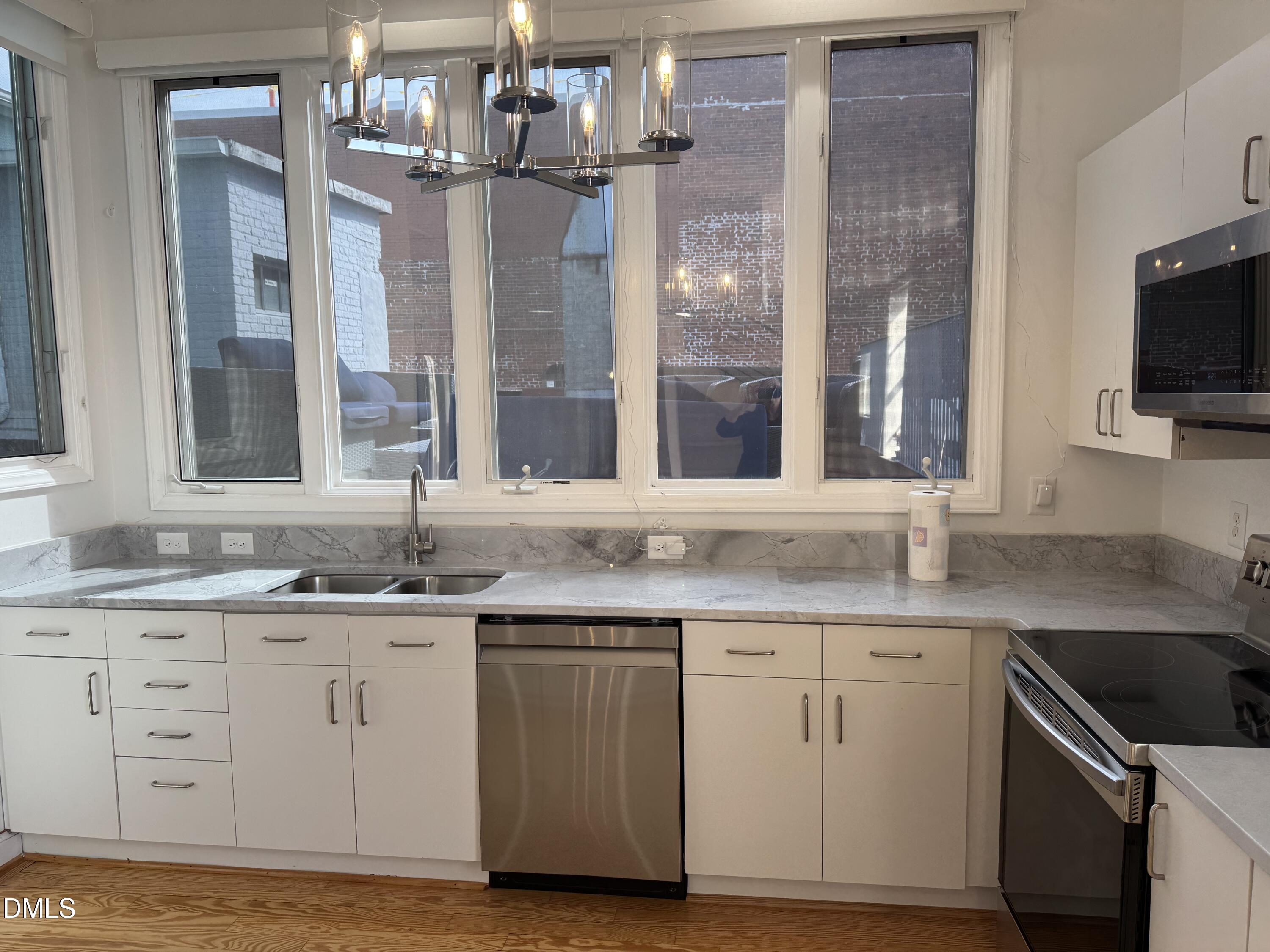 109 West Main Street, Unit 402 Durham, NC 27701 - Photo 8 of 19 a kitchen with granite countertop a sink and cabinets