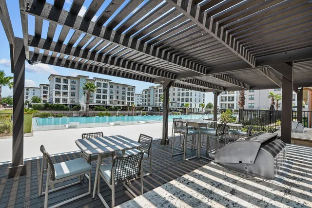 a view of a chairs and table in wooden roof deck