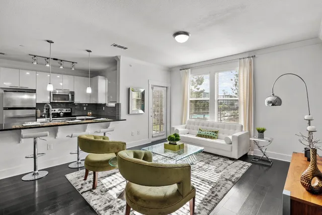 a living room with furniture and kitchen view