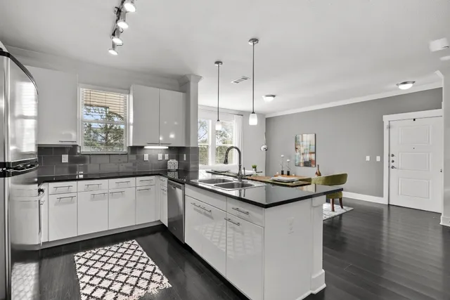 a kitchen with kitchen island granite countertop a sink appliances and cabinets
