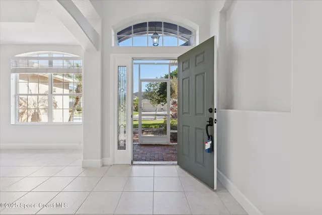 a view of a hallway with a chandelier fan and kitchen view