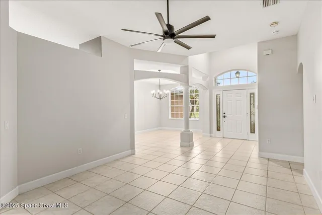 en view of an empty room and chandelier fan