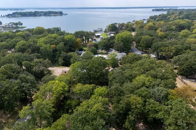 an aerial view of a house with a yard and lake view