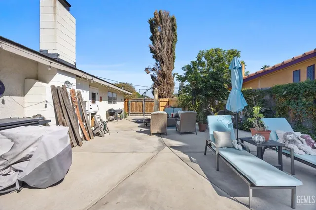 a view of backyard with outdoor seating and trees