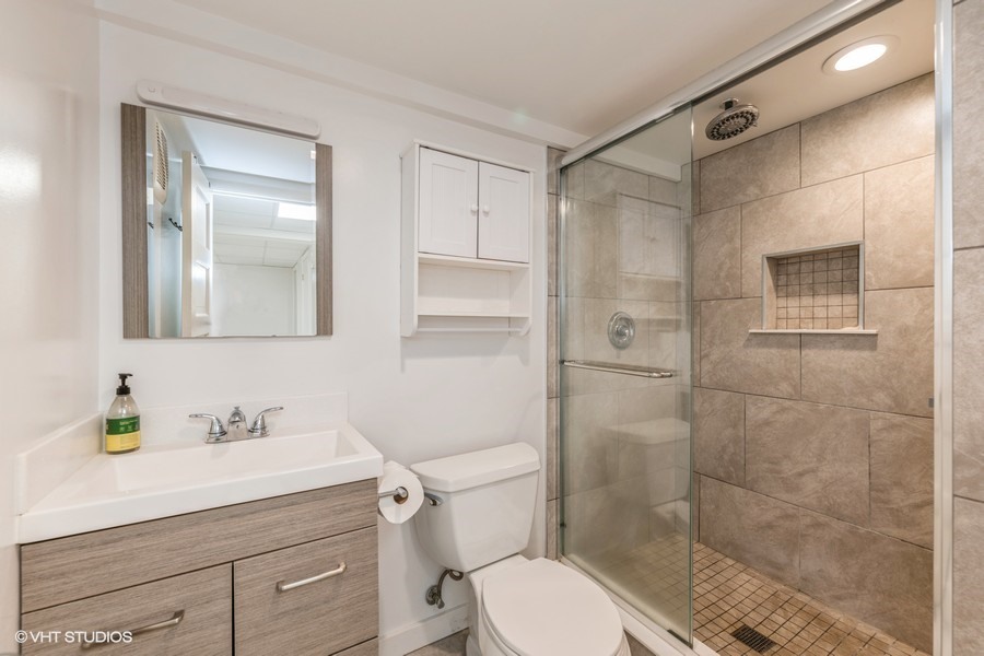107 Ridge Road Highland Park, IL 60035 - Photo 12 of 20 a bathroom with a shower a sink a toilet and a mirror