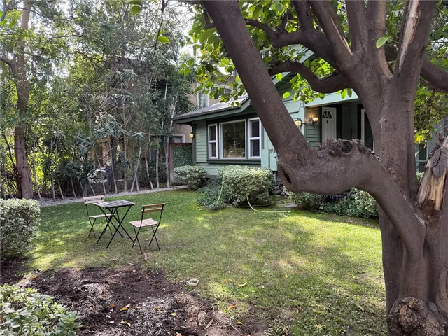 a view of a house with a yard in a forest
