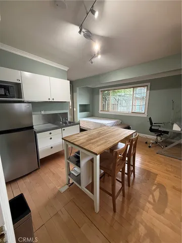 a kitchen with a table chairs sink and cabinets