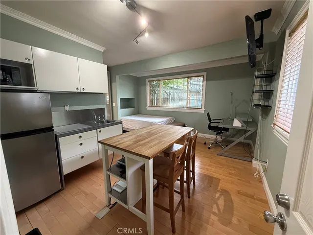 a kitchen with a table chairs refrigerator and microwave