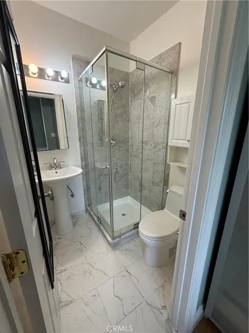 a bathroom with a shower a toilet a sink and a shower