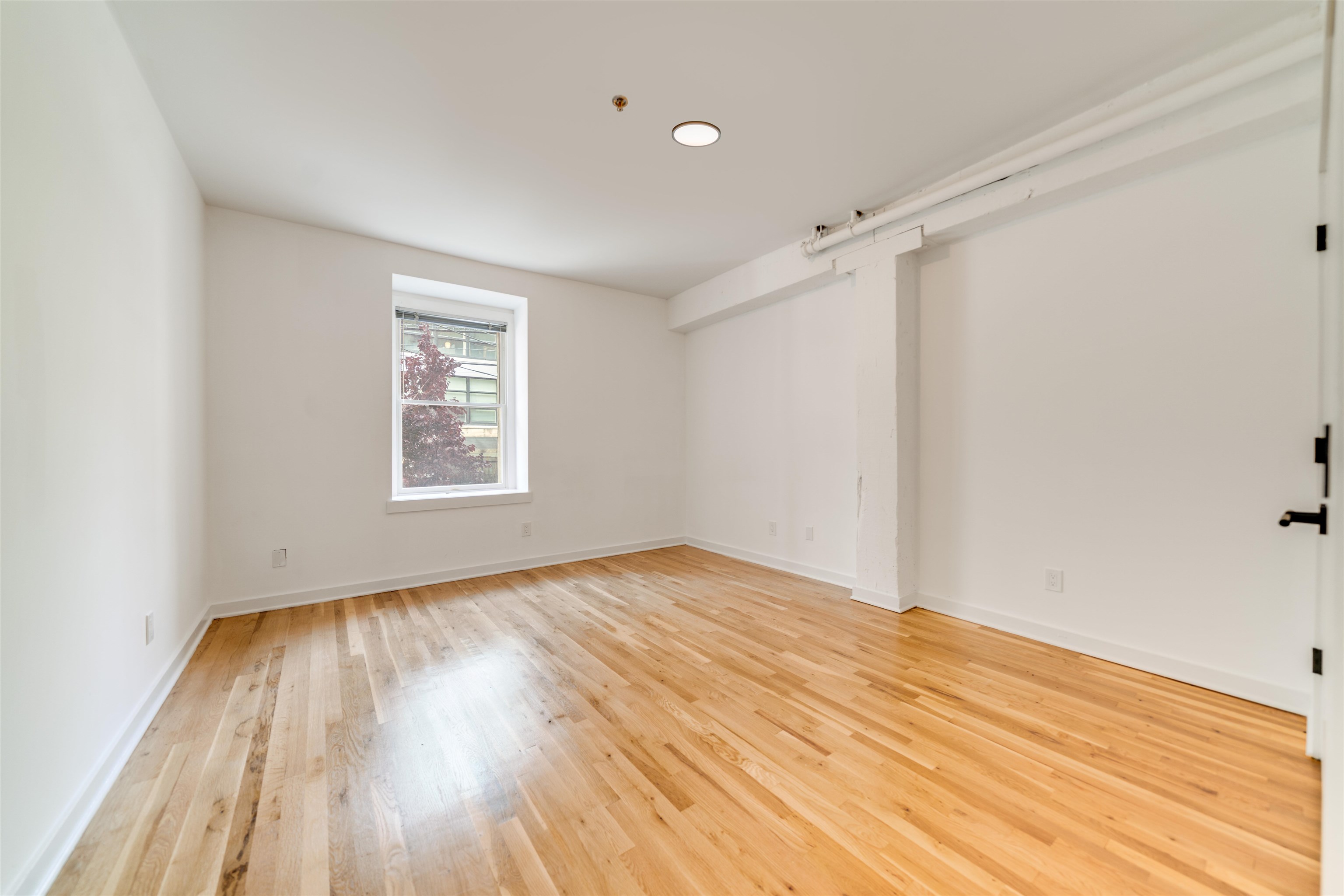 716 Madison Street, Unit 110A Hoboken, NJ 07030 - Photo 14 of 15 wooden floor in an empty room with a window