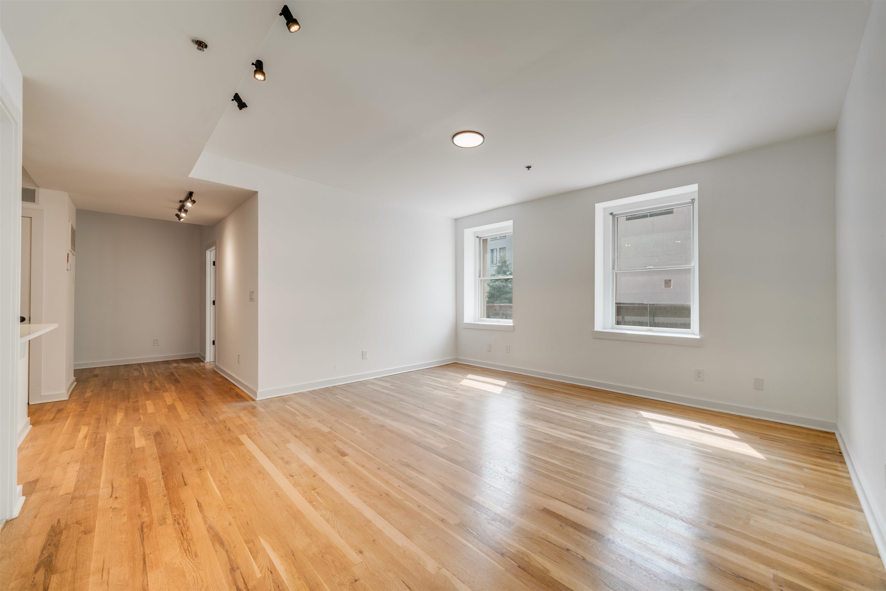 716 Madison Street, Unit 110A Hoboken, NJ 07030 - Photo 2 of 15 a view of an empty room with wooden floor and a window