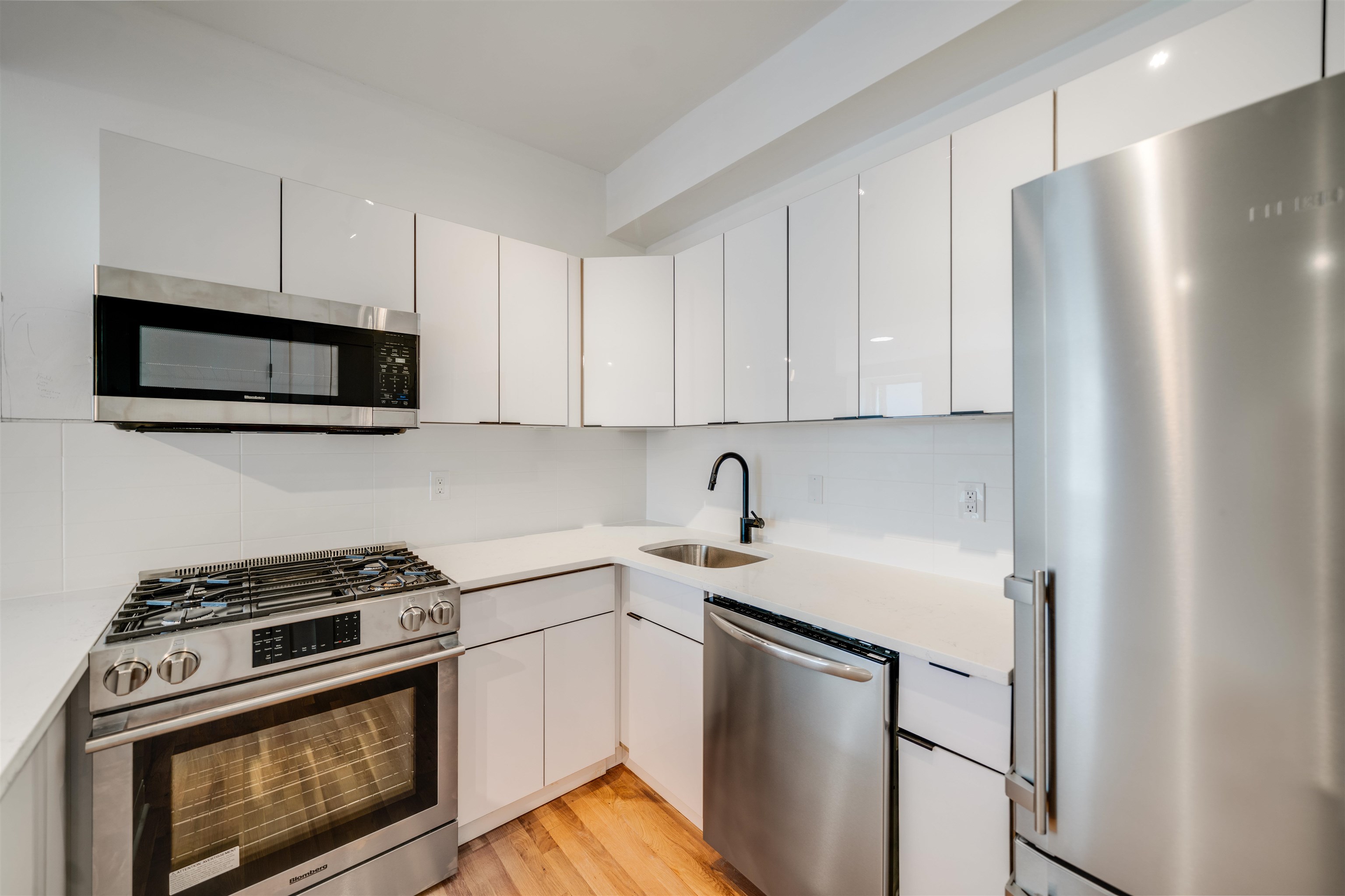 716 Madison Street, Unit 110A Hoboken, NJ 07030 - Photo 5 of 15 a kitchen with stainless steel appliances a stove a microwave and a refrigerator