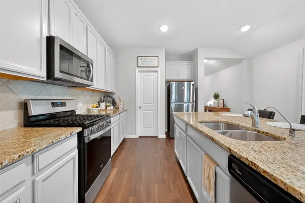 a kitchen with stainless steel appliances granite countertop a sink stove oven and refrigerator