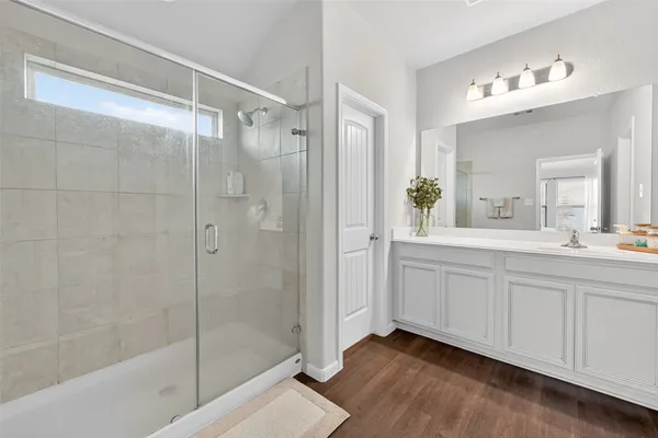 a spacious bathroom with a shower sink and mirror