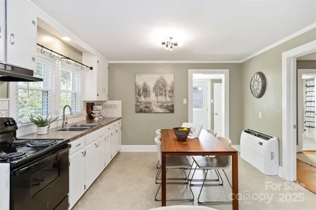 a kitchen with a dining table chairs and white cabinets