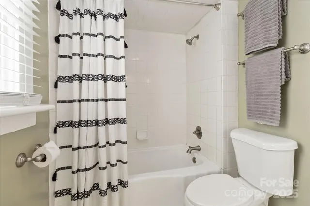 a white toilet sitting next to a bathroom sink and shower