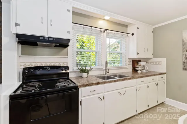 a kitchen with granite countertop white cabinets and white appliances
