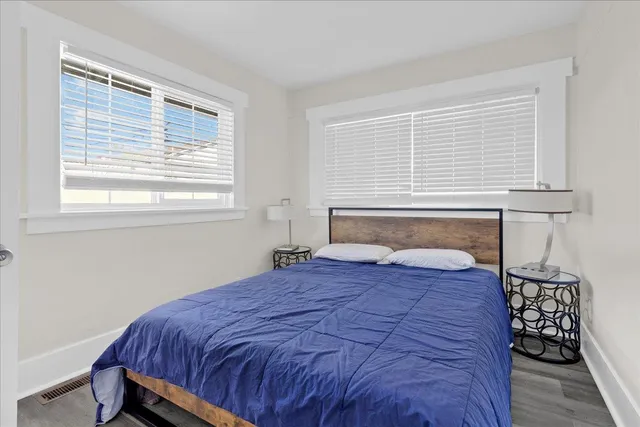 a bedroom with a bed and wooden floor
