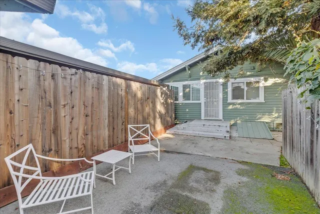 a backyard of a house with table and chairs