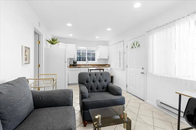 a living room with furniture and a refrigerator