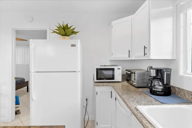a kitchen with stainless steel appliances white cabinets and a refrigerator